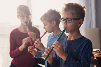 Three kids playing flutes together